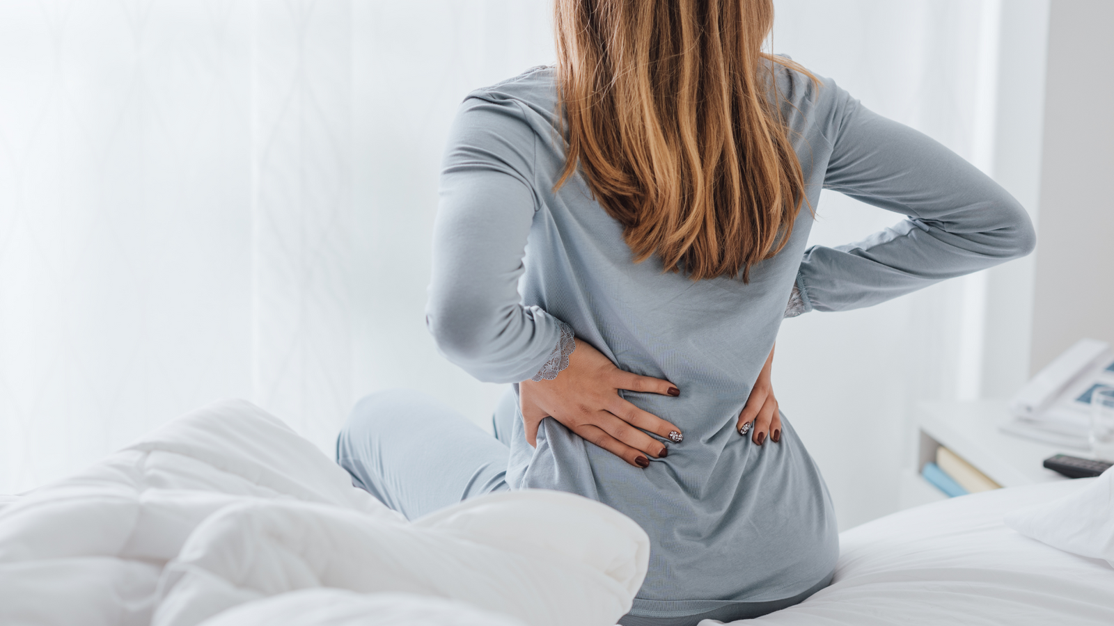 Femme sur un lit souffrant du dos à cause du RGO